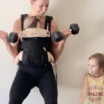 Mom exercising wearing her baby in a carrier