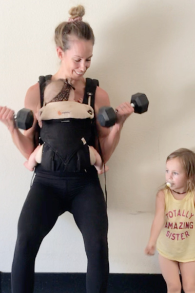 Mom exercising wearing her baby in a carrier