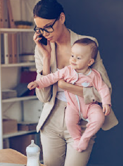 Mom juggling work at home while holding a baby