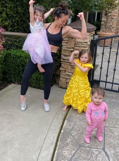 mom showing strong arms with her daughters