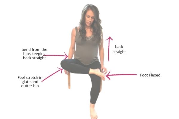 fit pregnant mom doing a seated pigeon pose for pregnancy back pain stretch 