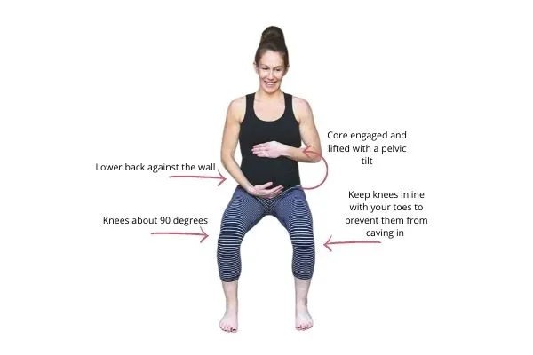 pregnant mom doing a wall squat exercise