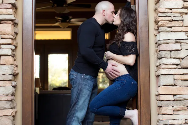 dad kissing pregnant mom with his hand on her belly