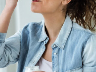 women in blue button up shirt enjoying her food with a spoon