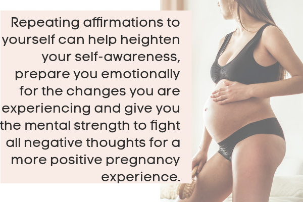 pregnant mom in black bathing suit with hand on her belly holding a brush representing a positive pregnancy